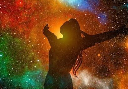 A woman standing in front of the stars with her arms outstretched.